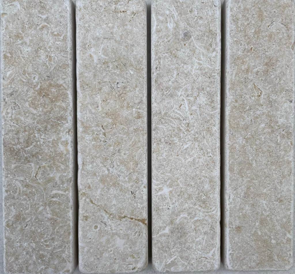 Slim tumbled natural stone batons laid in a soft neutral herringbone pattern, showing subtle surface variation and texture, suitable for indoor or outdoor use.