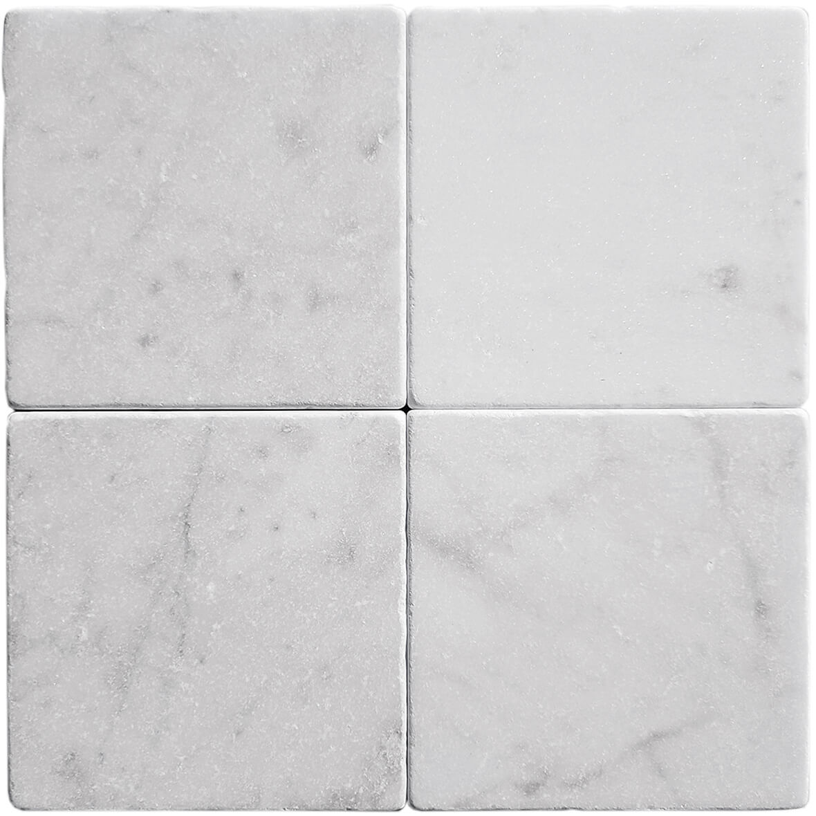 Tumbled square natural stone tiles in mixed neutral tones, laid in a soft grid across an outdoor floor. Visible variation and softened edges.