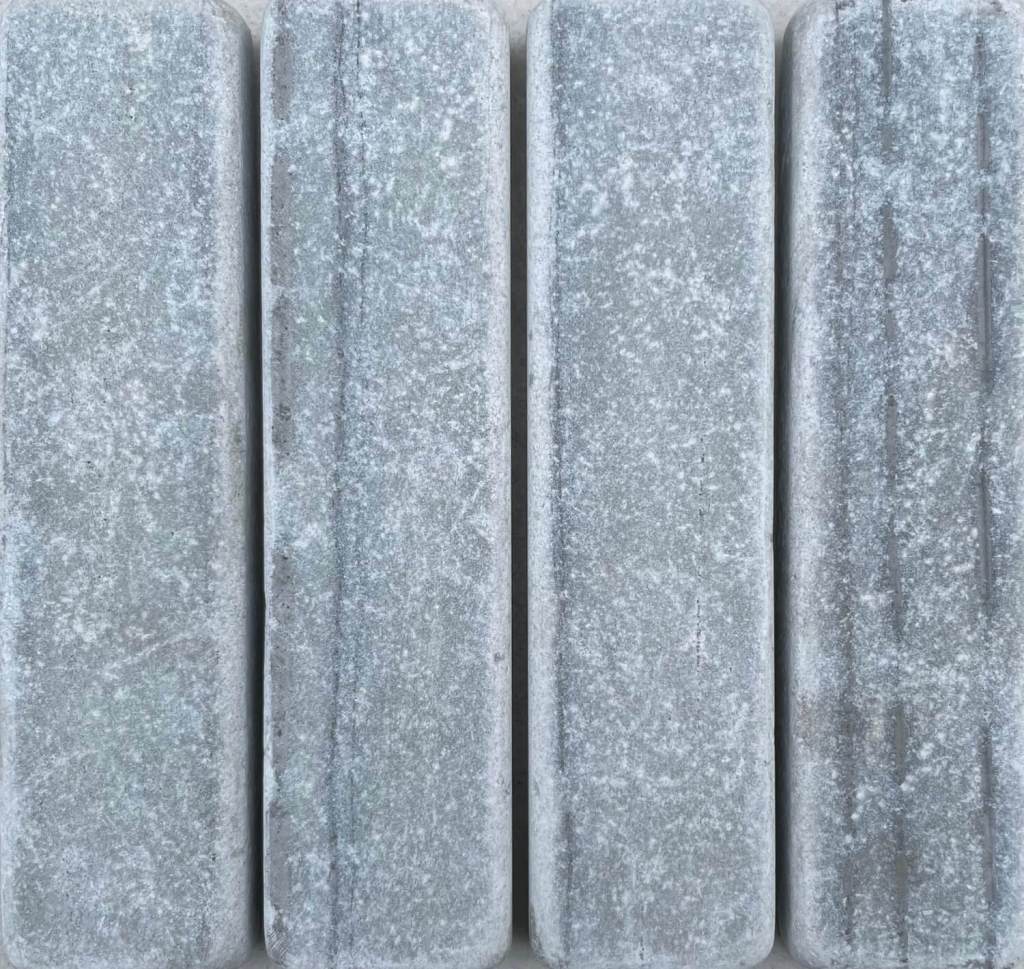 Slim tumbled natural stone batons laid in a soft neutral herringbone pattern, showing subtle surface variation and texture, suitable for indoor or outdoor use.
