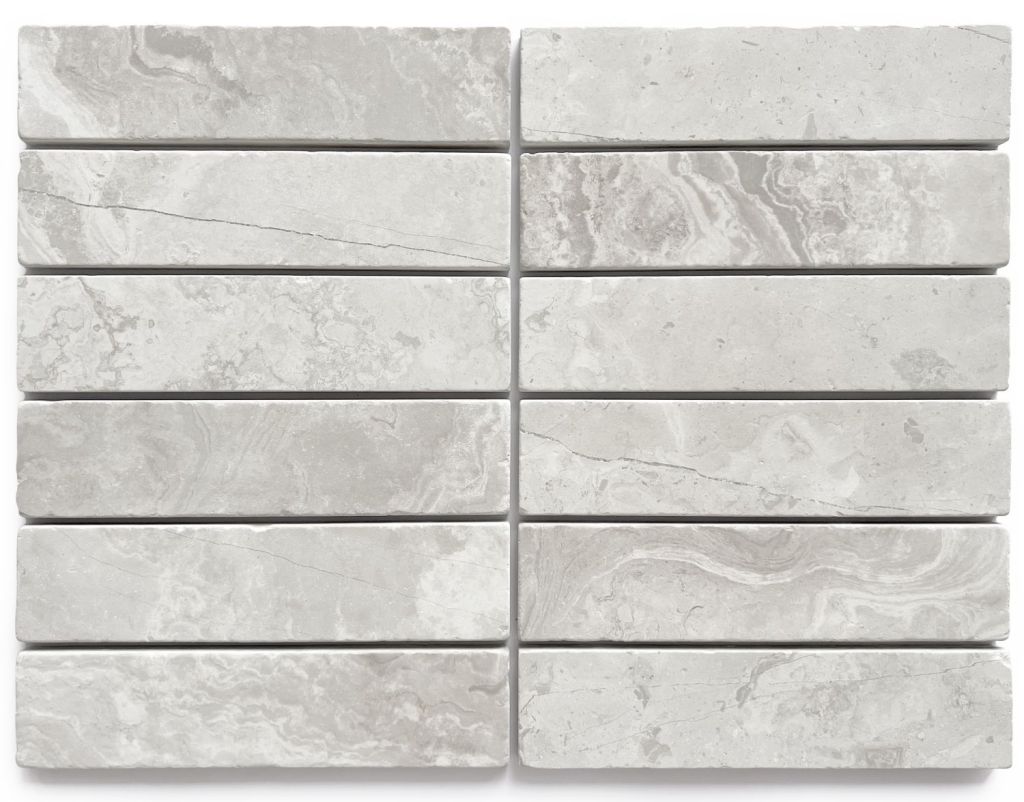 Slim tumbled natural stone batons laid in a soft neutral herringbone pattern, showing subtle surface variation and texture, suitable for indoor or outdoor use.