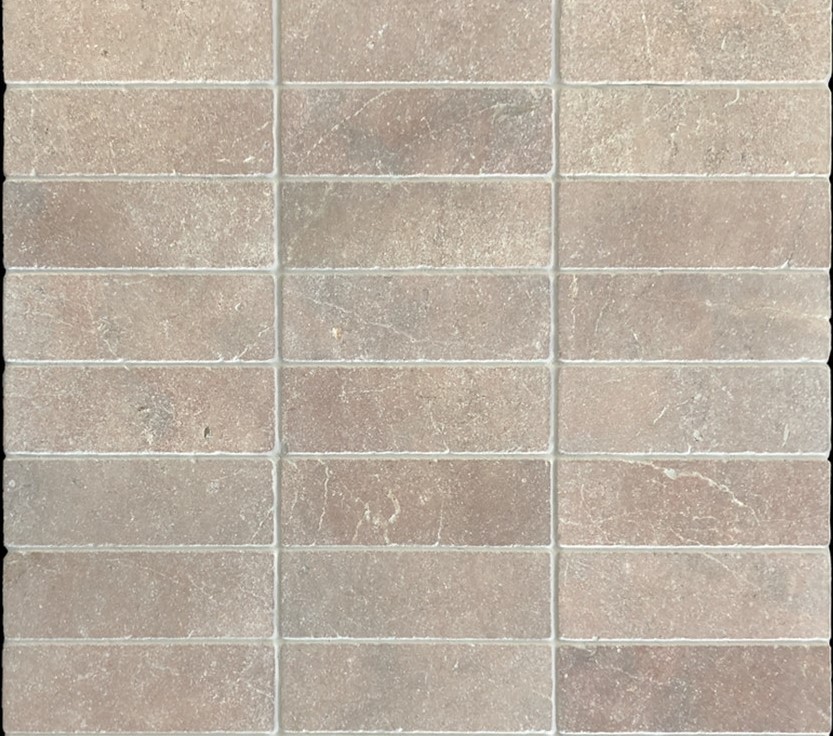 Slim tumbled natural stone batons laid in a soft neutral herringbone pattern, showing subtle surface variation and texture, suitable for indoor or outdoor use.