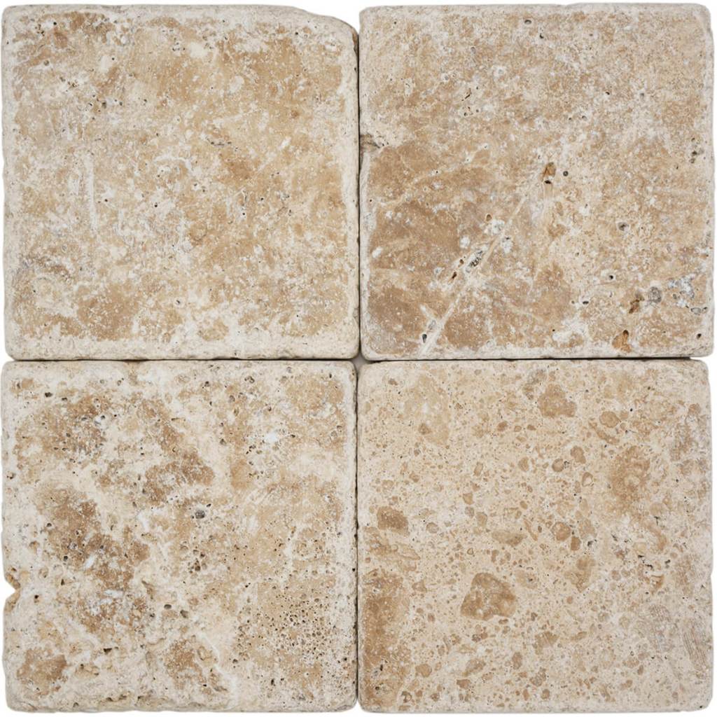 Tumbled square natural stone tiles in mixed neutral tones, laid in a soft grid across an outdoor floor. Visible variation and softened edges.