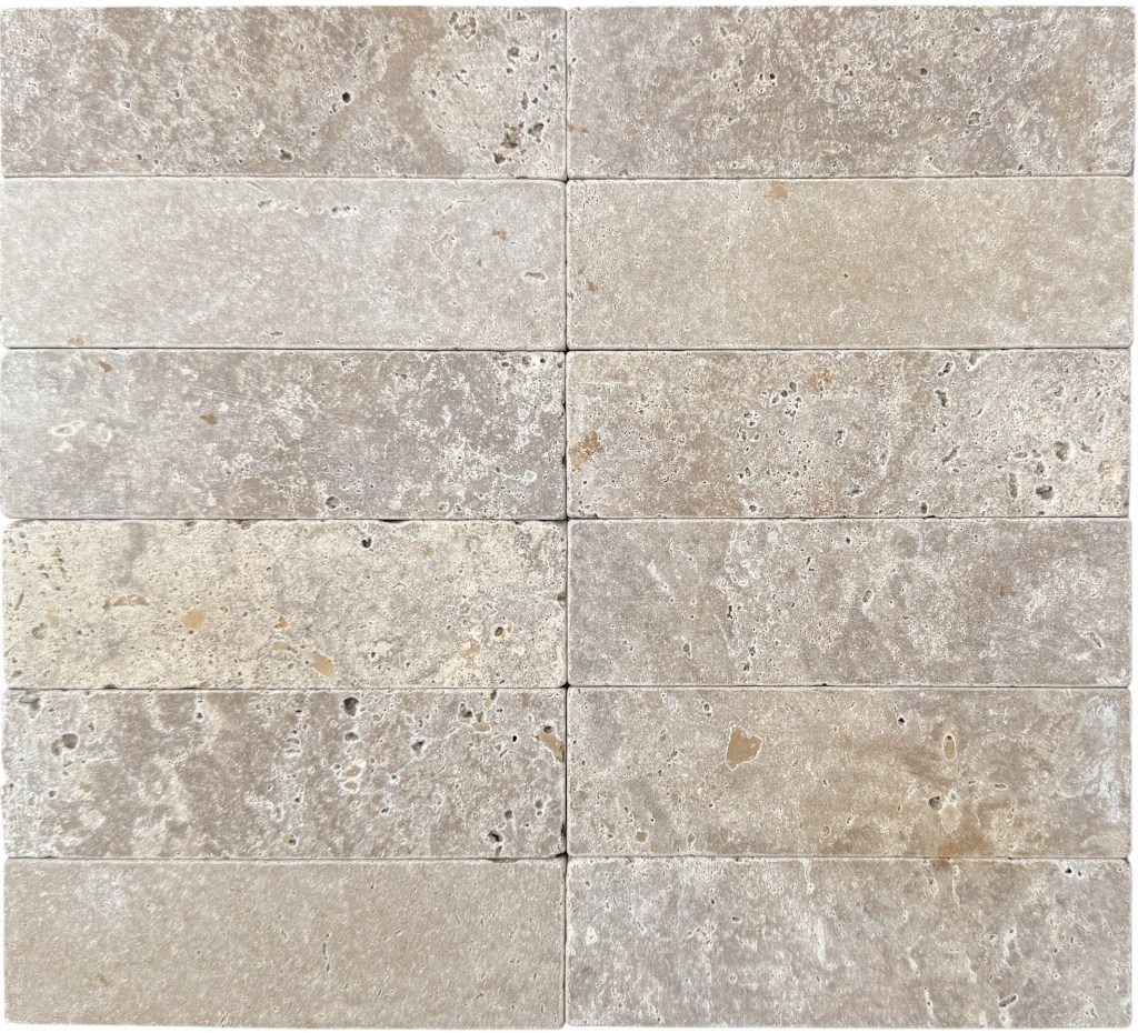 Slim tumbled natural stone batons laid in a soft neutral herringbone pattern, showing subtle surface variation and texture, suitable for indoor or outdoor use.