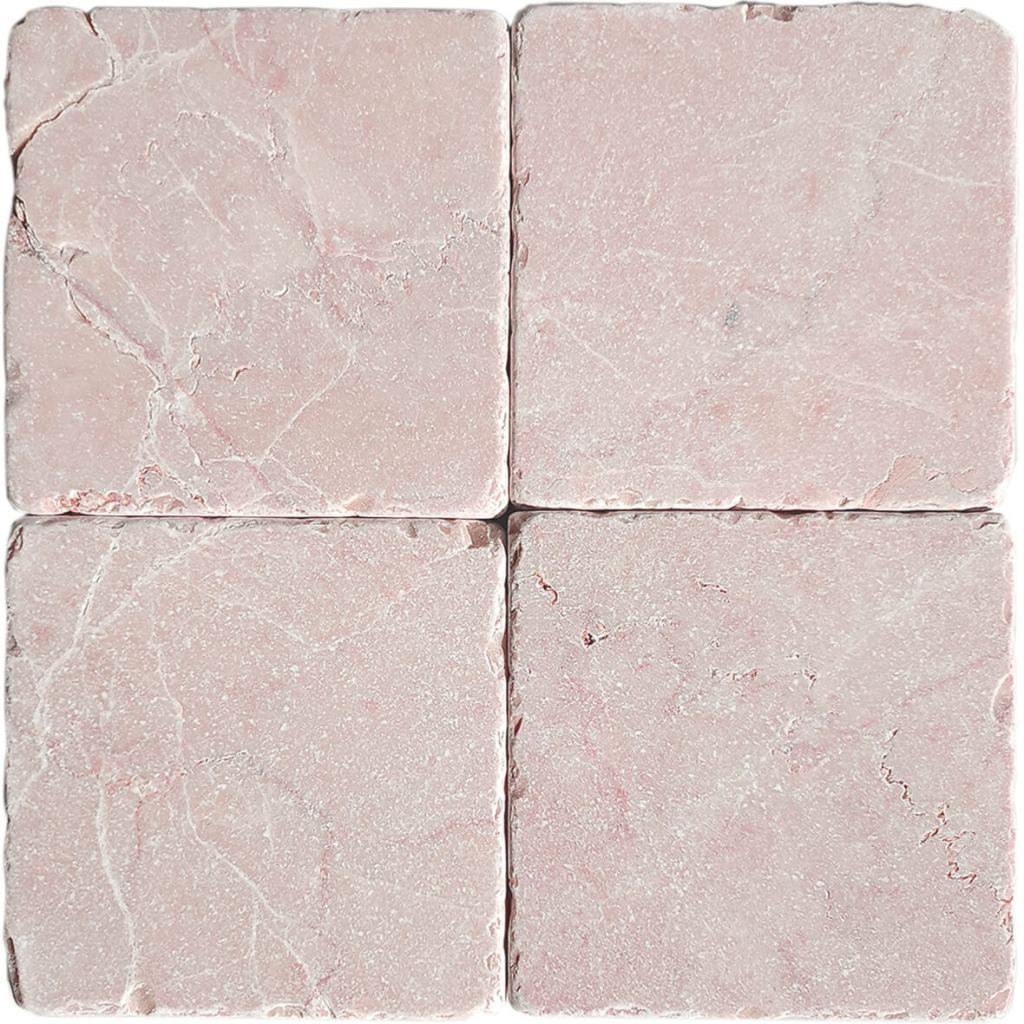Tumbled square natural stone tiles in mixed neutral tones, laid in a soft grid across an outdoor floor. Visible variation and softened edges.