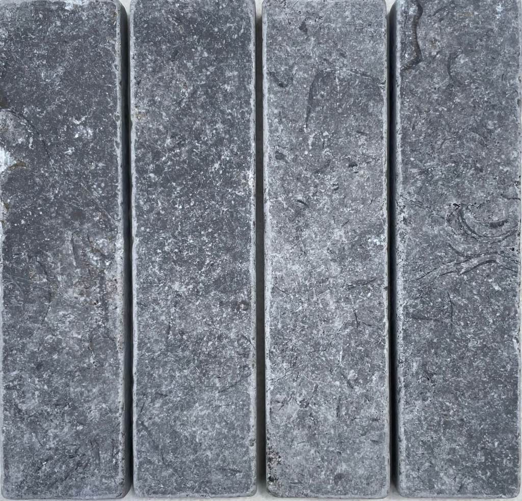Slim tumbled natural stone batons laid in a soft neutral herringbone pattern, showing subtle surface variation and texture, suitable for indoor or outdoor use.