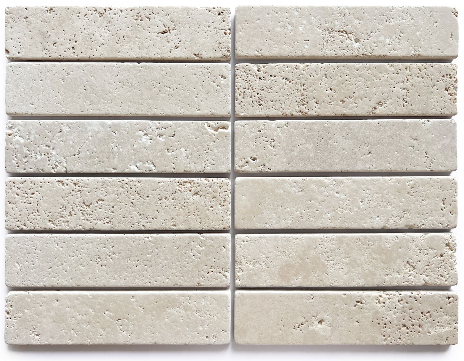 Slim tumbled natural stone batons laid in a soft neutral herringbone pattern, showing subtle surface variation and texture, suitable for indoor or outdoor use.