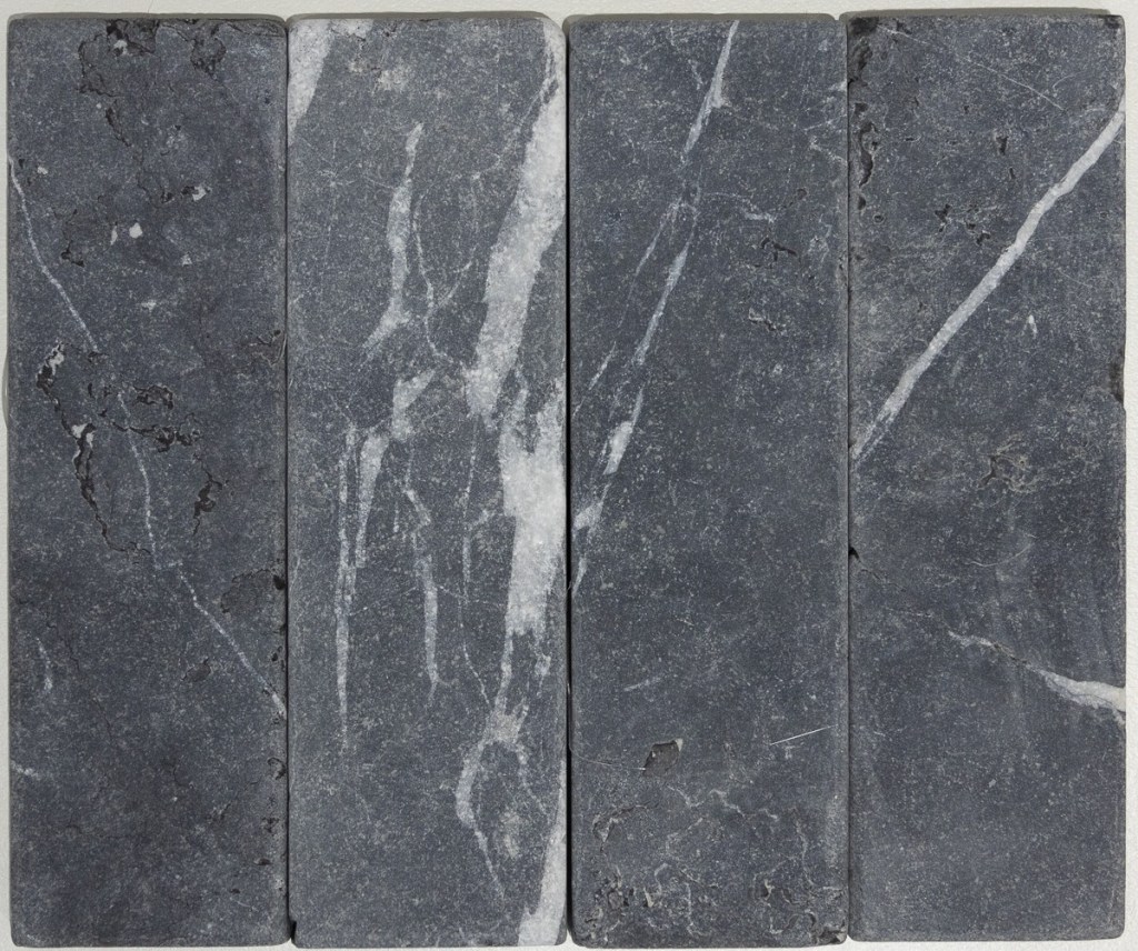Slim tumbled natural stone batons laid in a soft neutral herringbone pattern, showing subtle surface variation and texture, suitable for indoor or outdoor use.