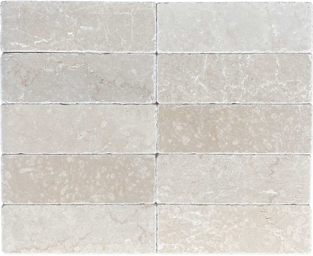 Slim tumbled natural stone batons laid in a soft neutral herringbone pattern, showing subtle surface variation and texture, suitable for indoor or outdoor use.